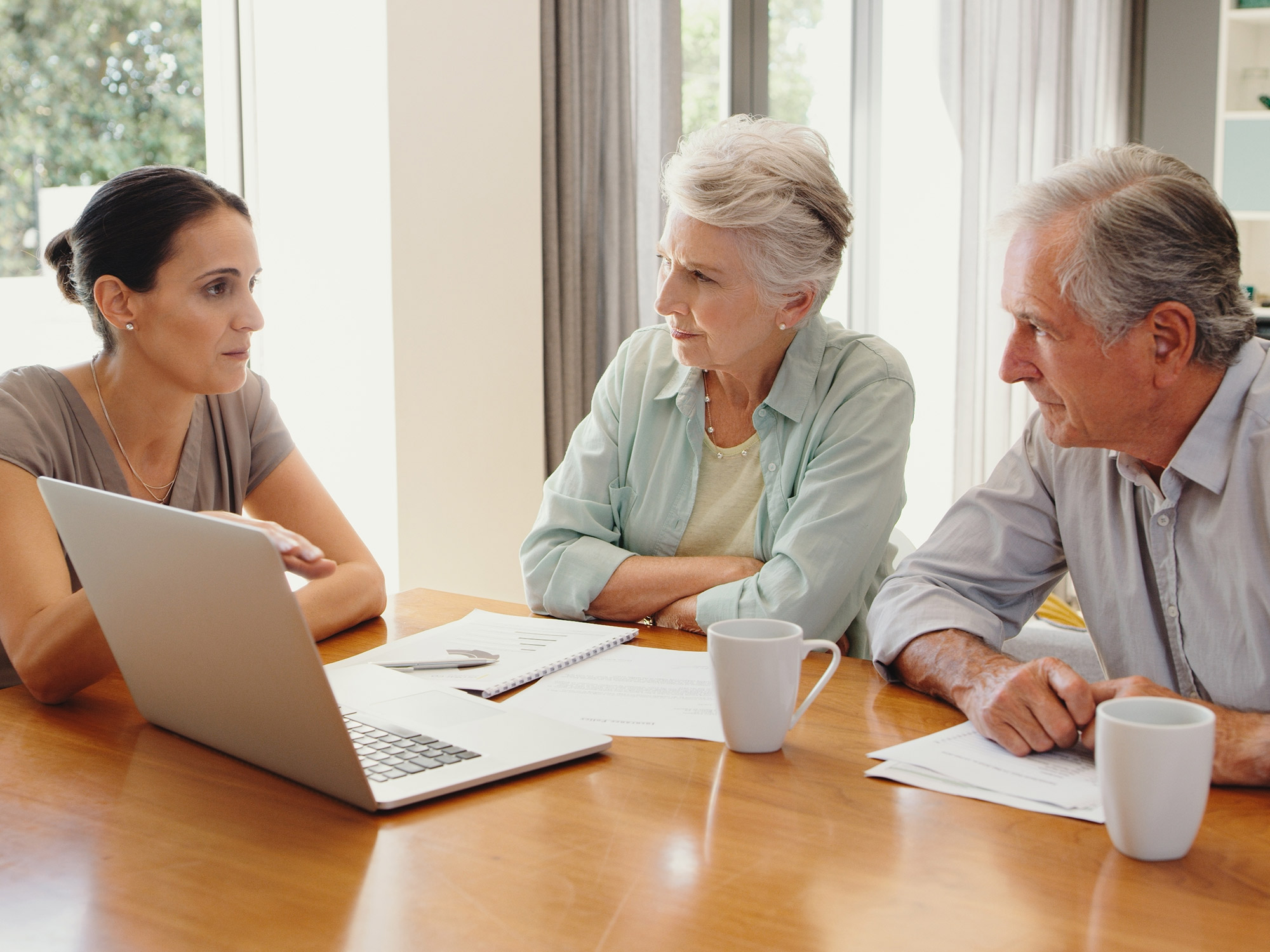 senior couple and their daughter on the computer together