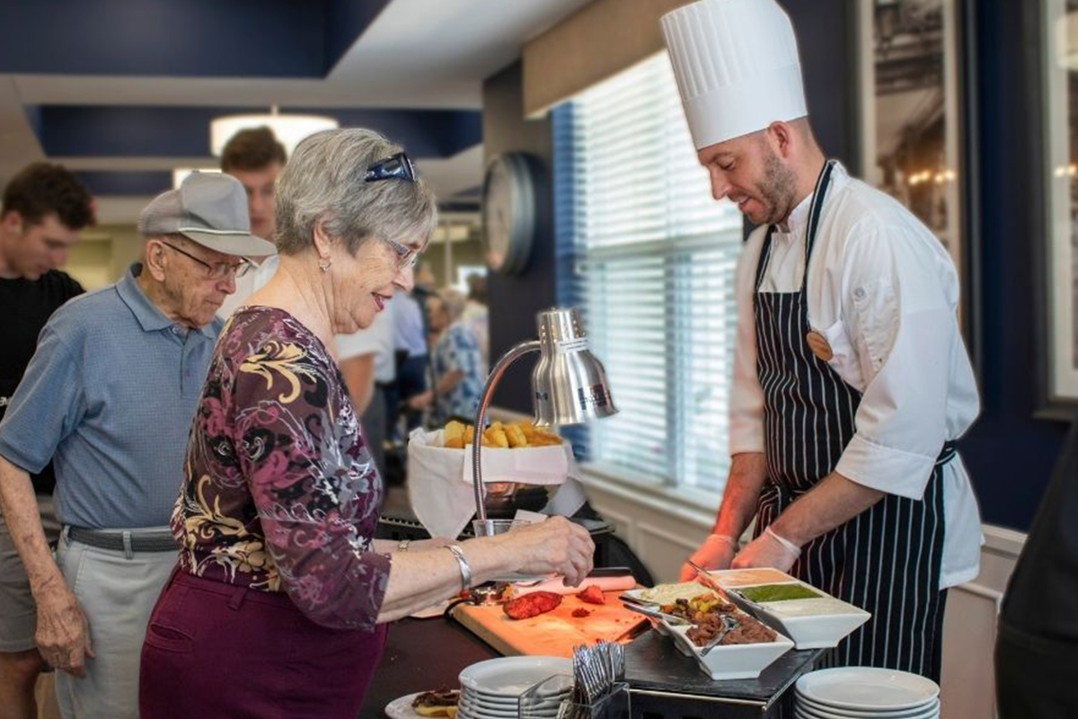 chef serving food to a StoryPoint resident