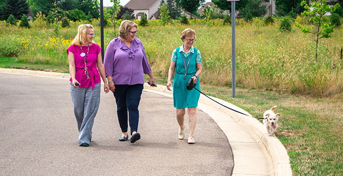 StoryPoint resident and team members walking pets around the senior living community