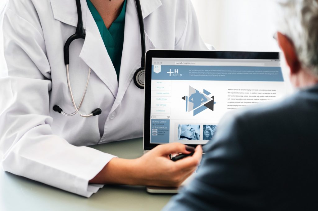 doctor showing a senior his computer screen