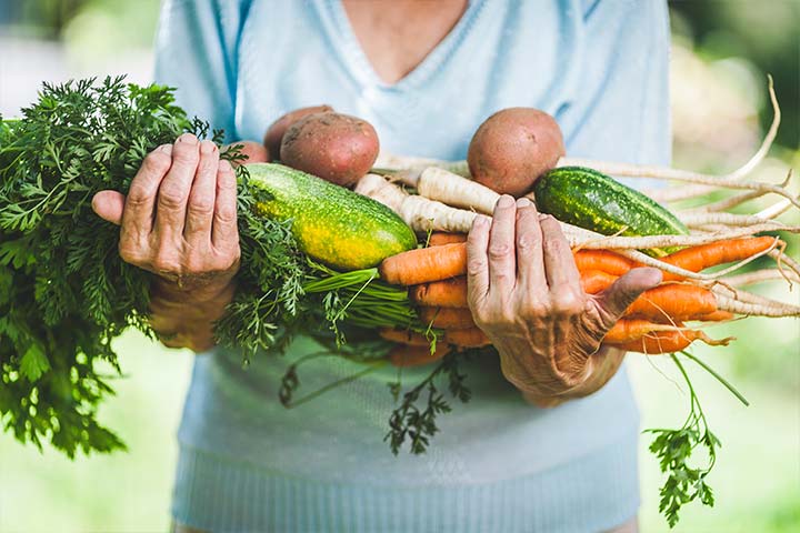 woman with her hands full of in-season vegetables 