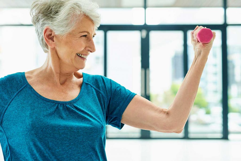 senior using weights to exercise