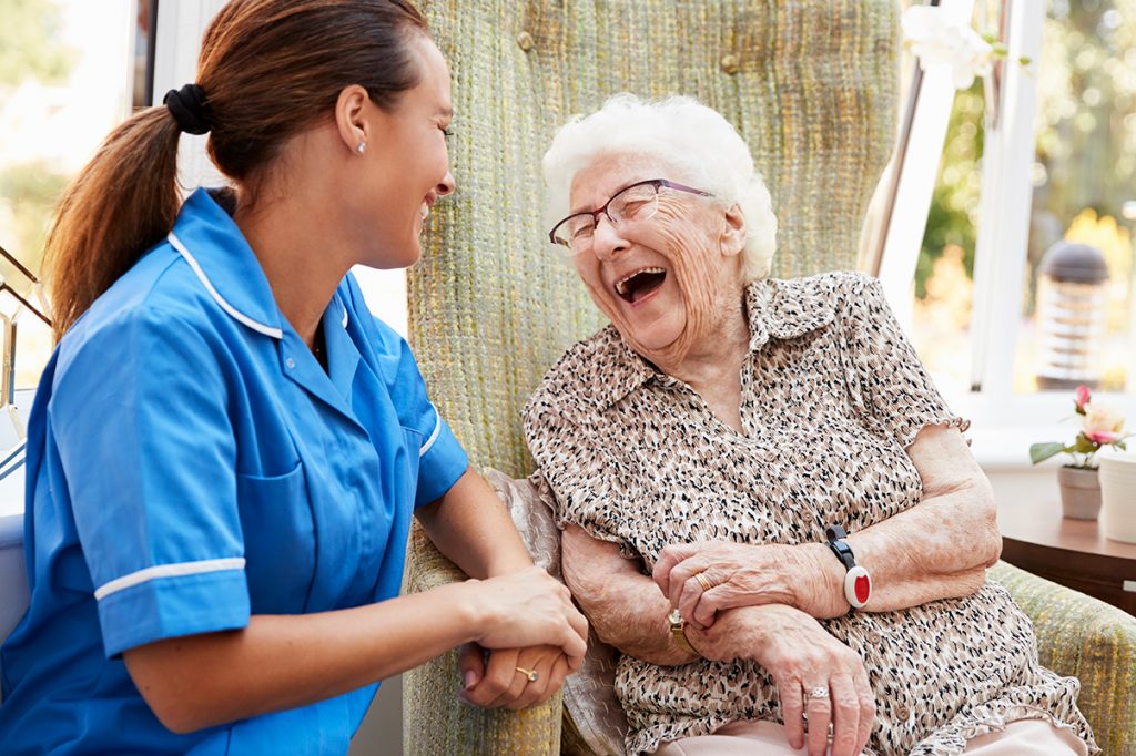 senior woman and caregiver laughing