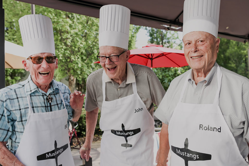 seniors outside wearing aprons cooking