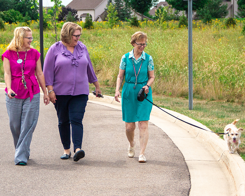 StoryPoint resident walking her dog with employees