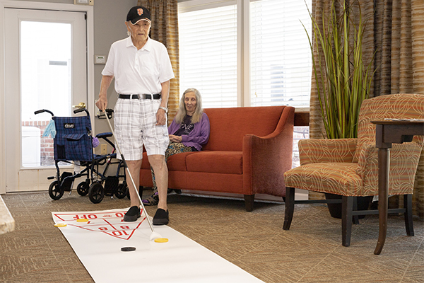 Senior man playing a shuffleboard game at IV Ames