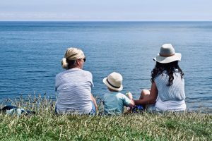 family sitting at the beach