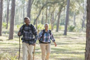 Older African American couple hiking through the woods