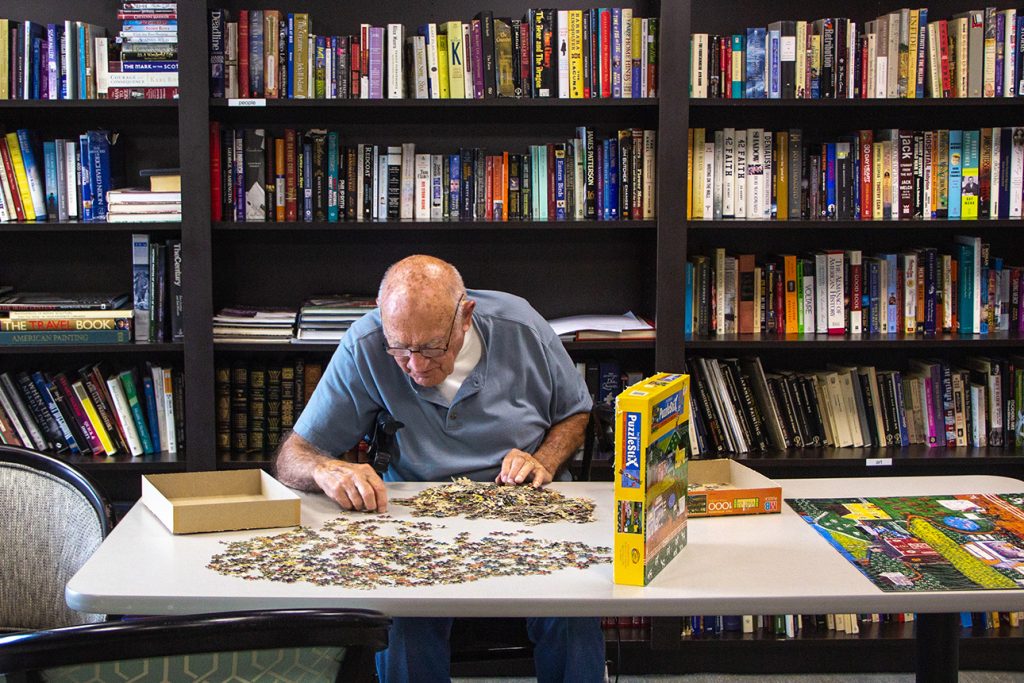 elderly senior man enjoying his hobby of puzzling at Independence Village