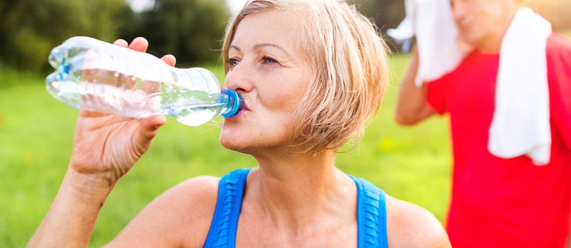 senior drinking water after exercising 