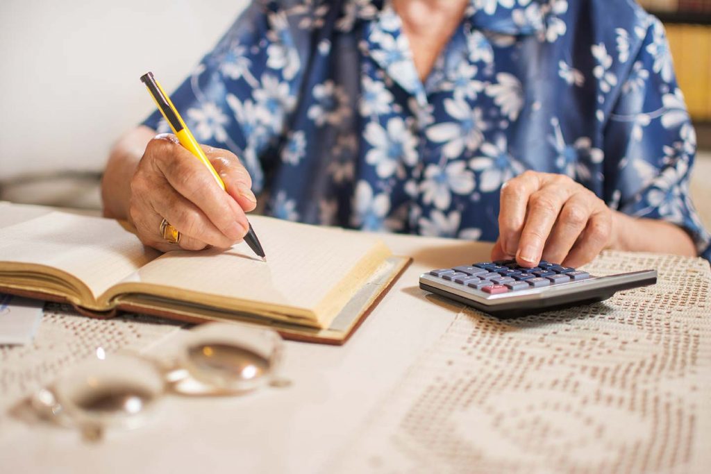 senior calculating her finances for senior living expenses