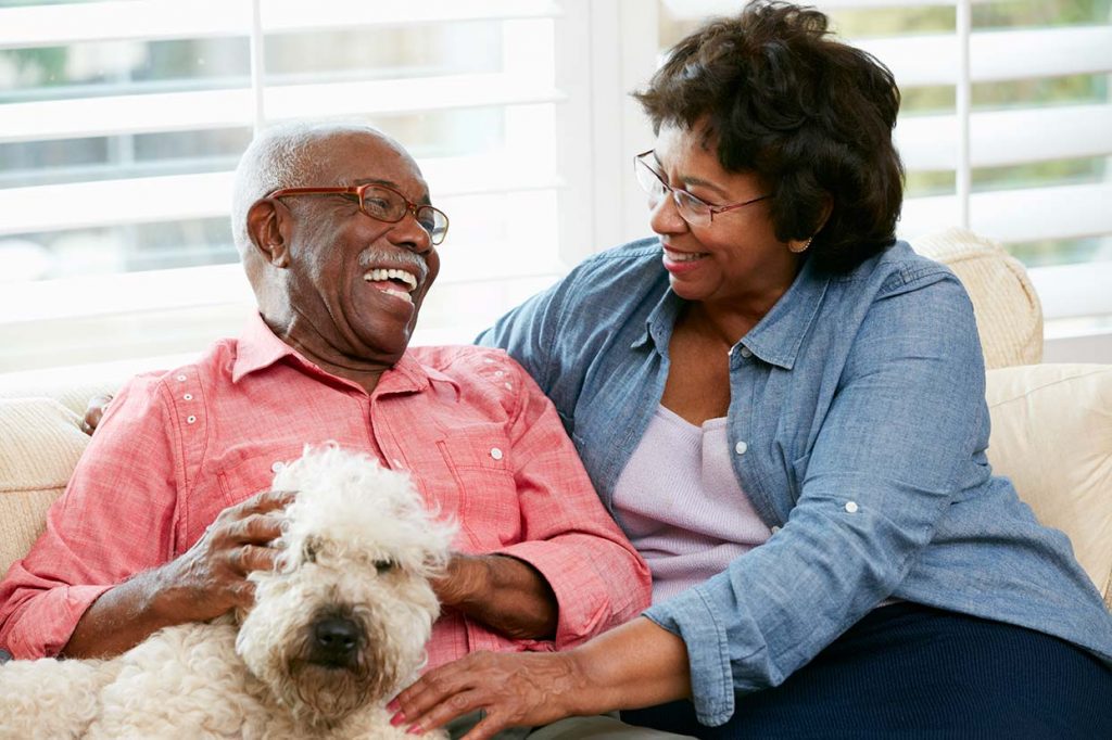 senor couple with their dog and smiling