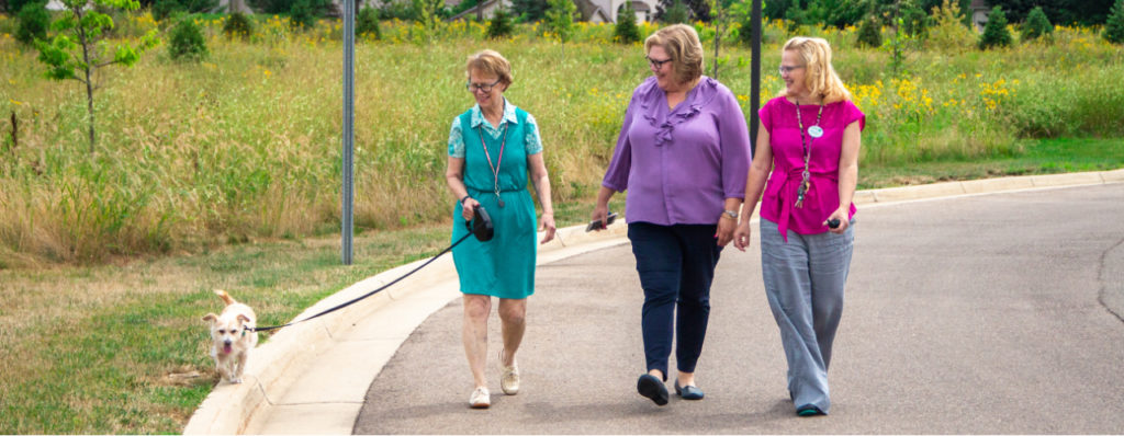 StoryPoint resident walking her dog with employees