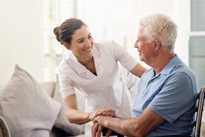 caregiver helping out a senior in his living room