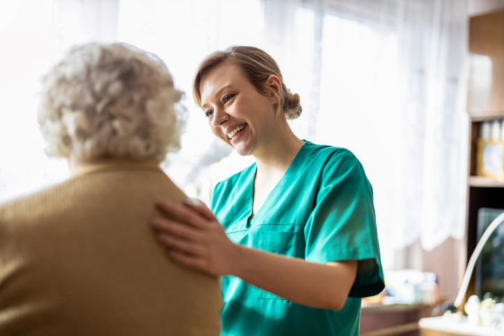 caregiving smiling at senior woman resident