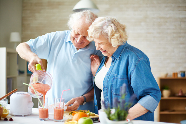 two seniors pouring a smoothie