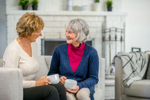 senior drinking tea with caregiver