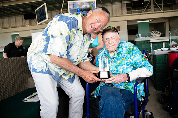 StroyPoint resident holding trophy at 100th birthday event at Churchill Downs