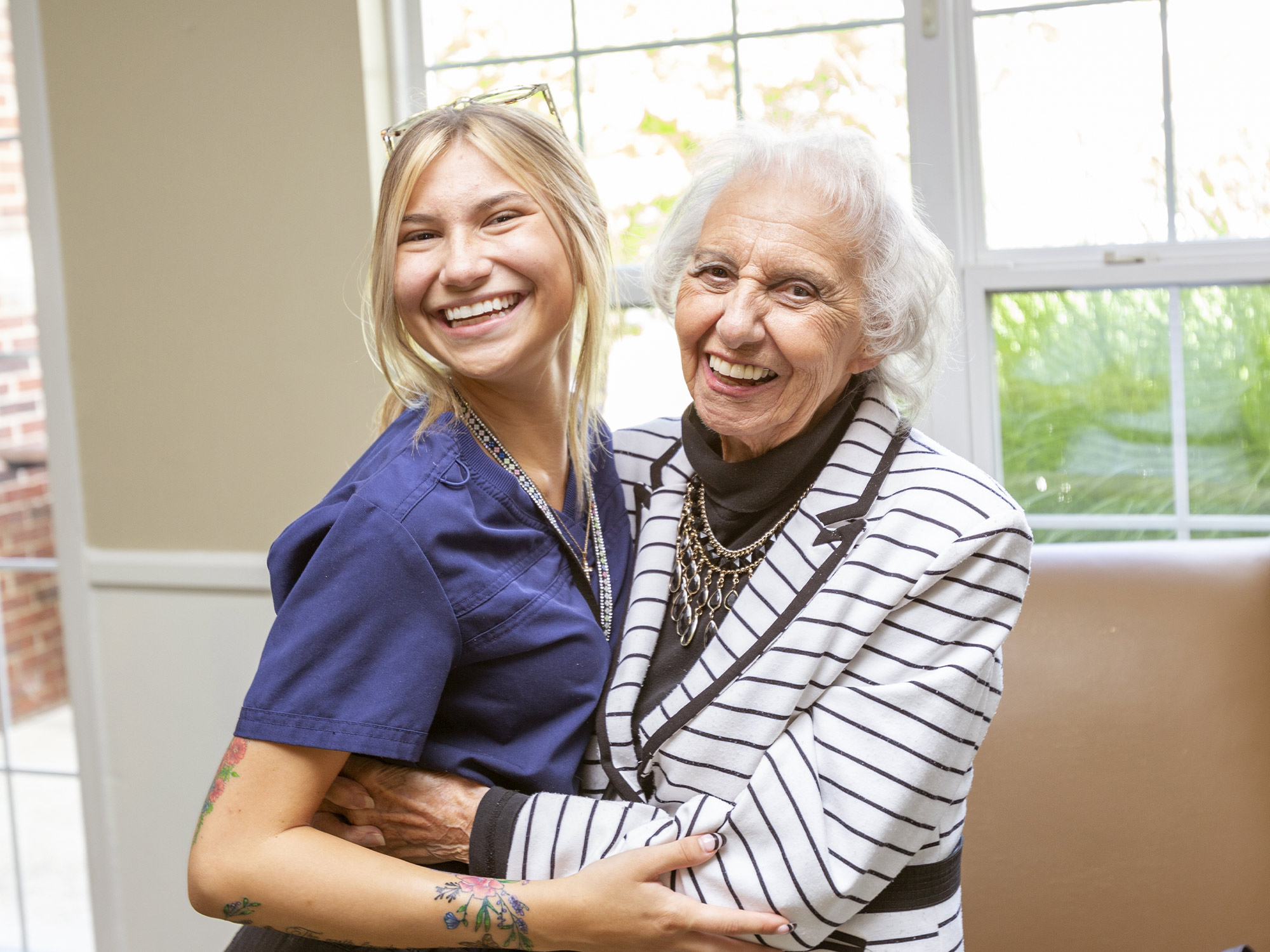 nurse and senior hugging