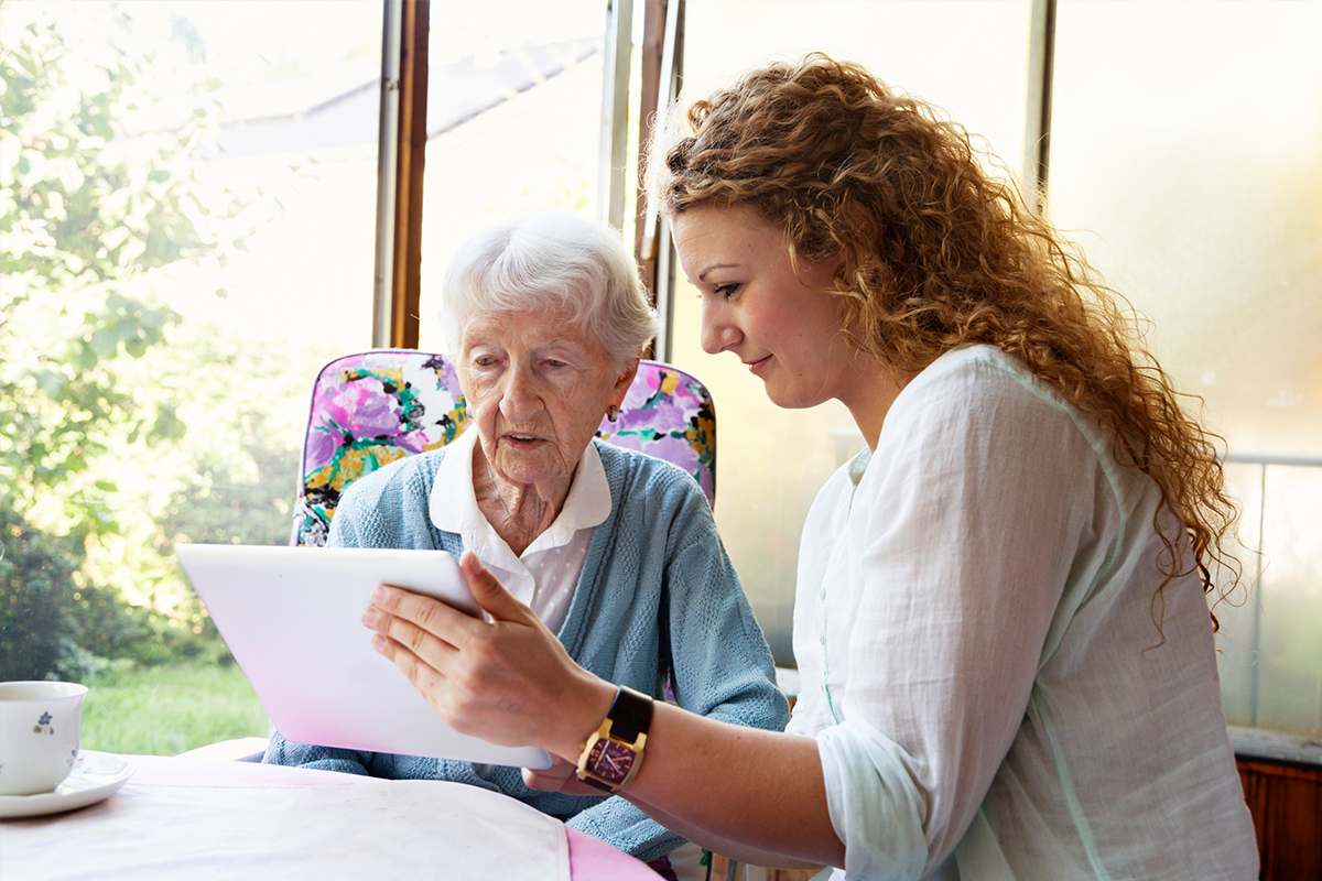 Senior looking at a tablet with her daughter