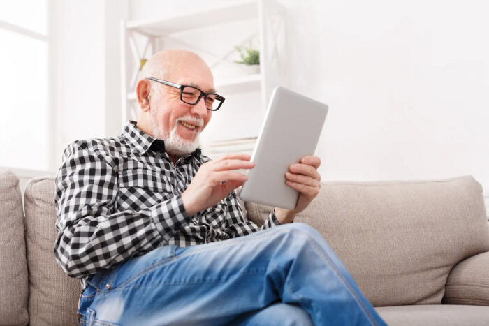 senior using a tablet on the couch