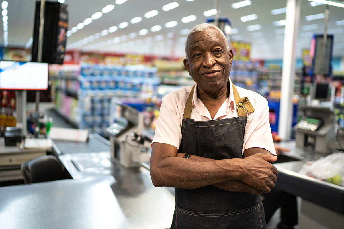 Senior man working as a cashier at a grocery store