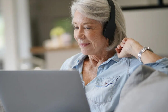 senior listening to an audiobook on headphones