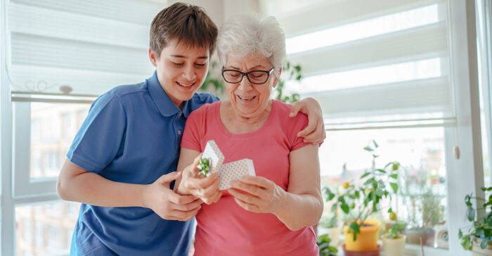 senior woman opening a gift with her grandchild