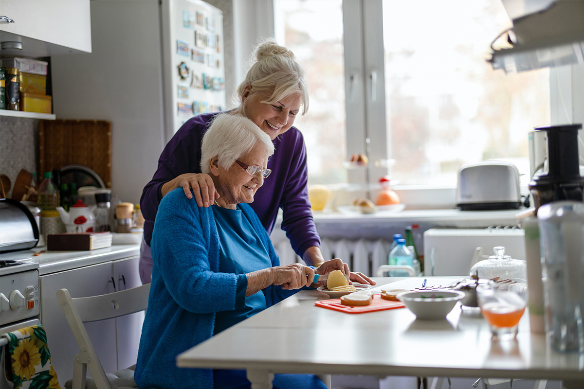 Senior in the kitchen cutting food 