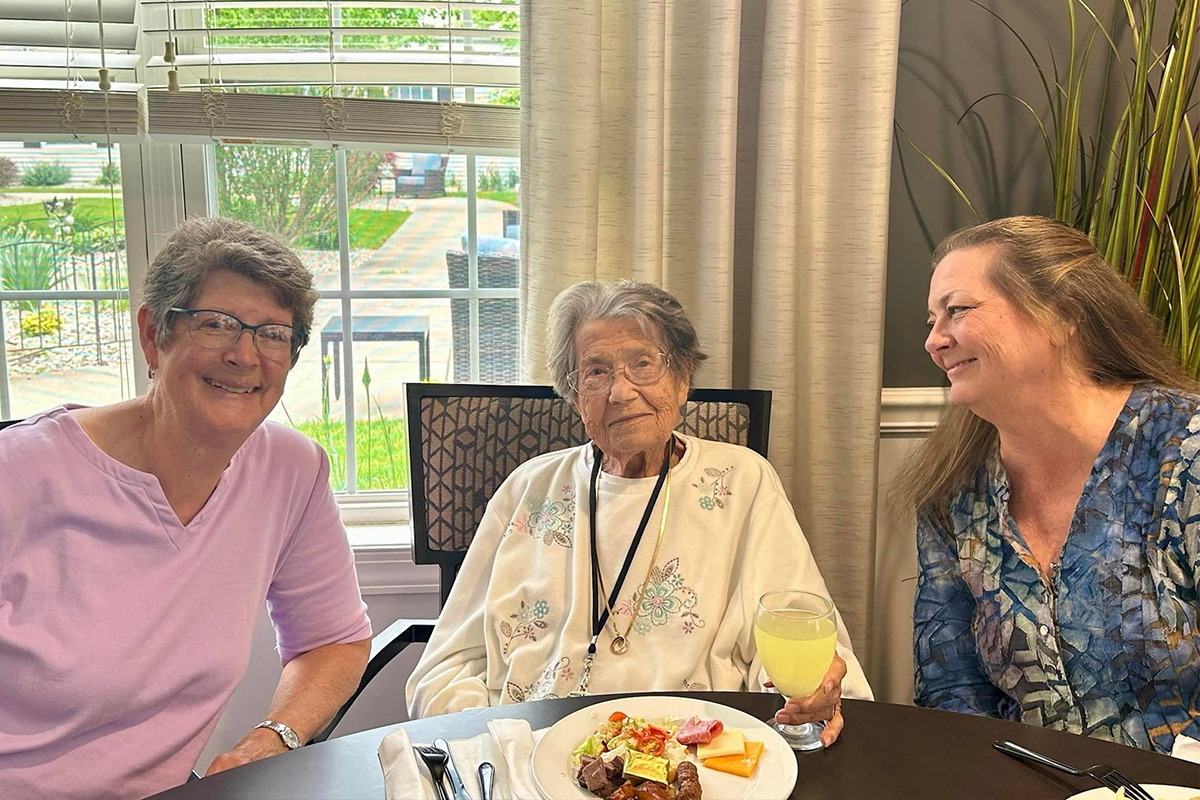 StoryPoint memory care resident with her loved ones eating breakfast