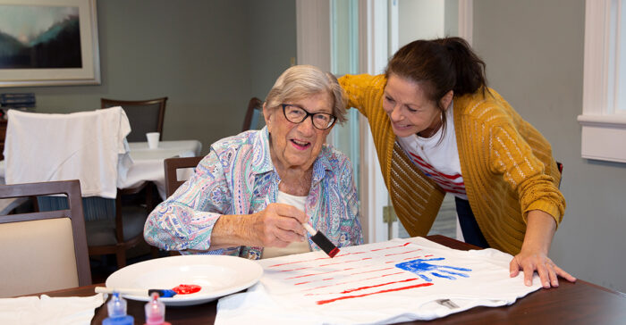 senior with dementia painting with a caregiver