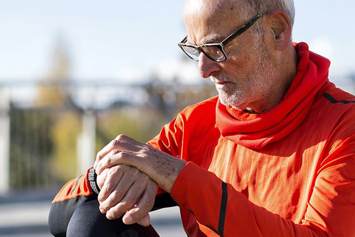 Senior man checking his smart watch outdoors.