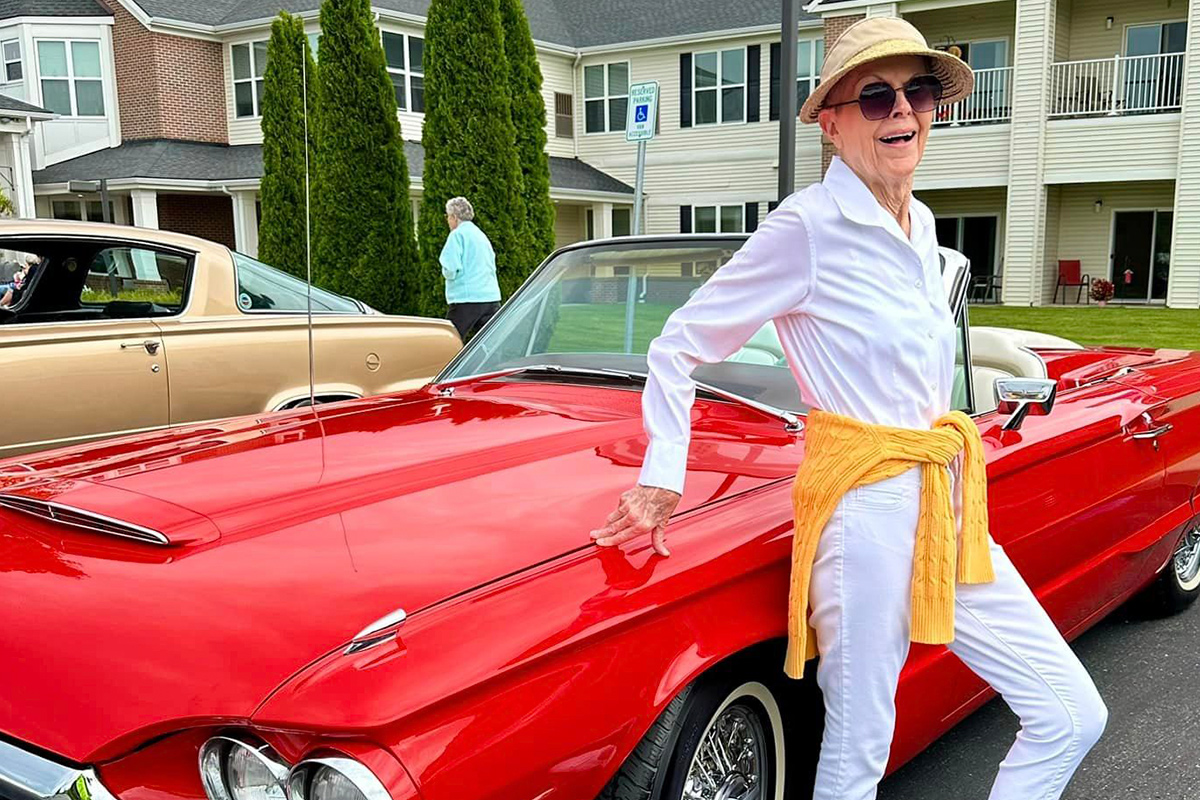 StoryPoint resident standing next to a classic car