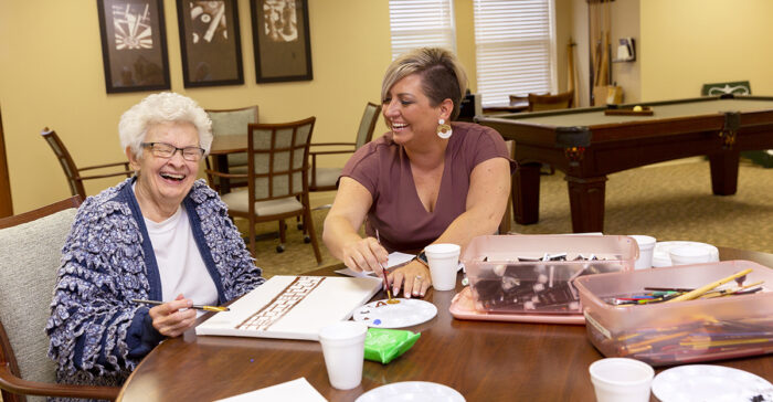 StoryPoint Group resident and caregiver painting together.