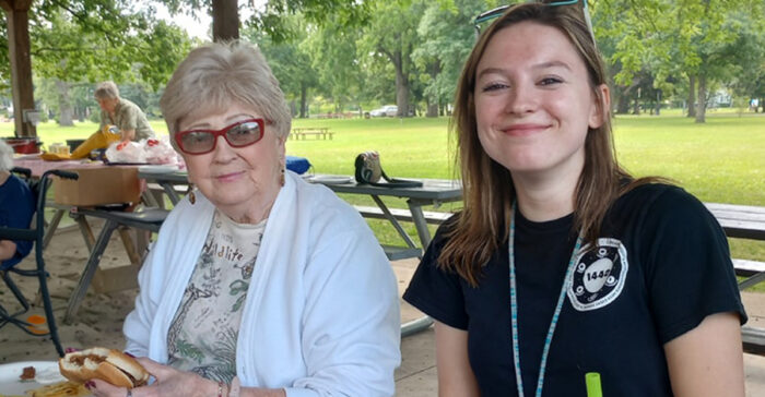 Oliver Woods resident and caregiver enjoy an outdoor picnic.