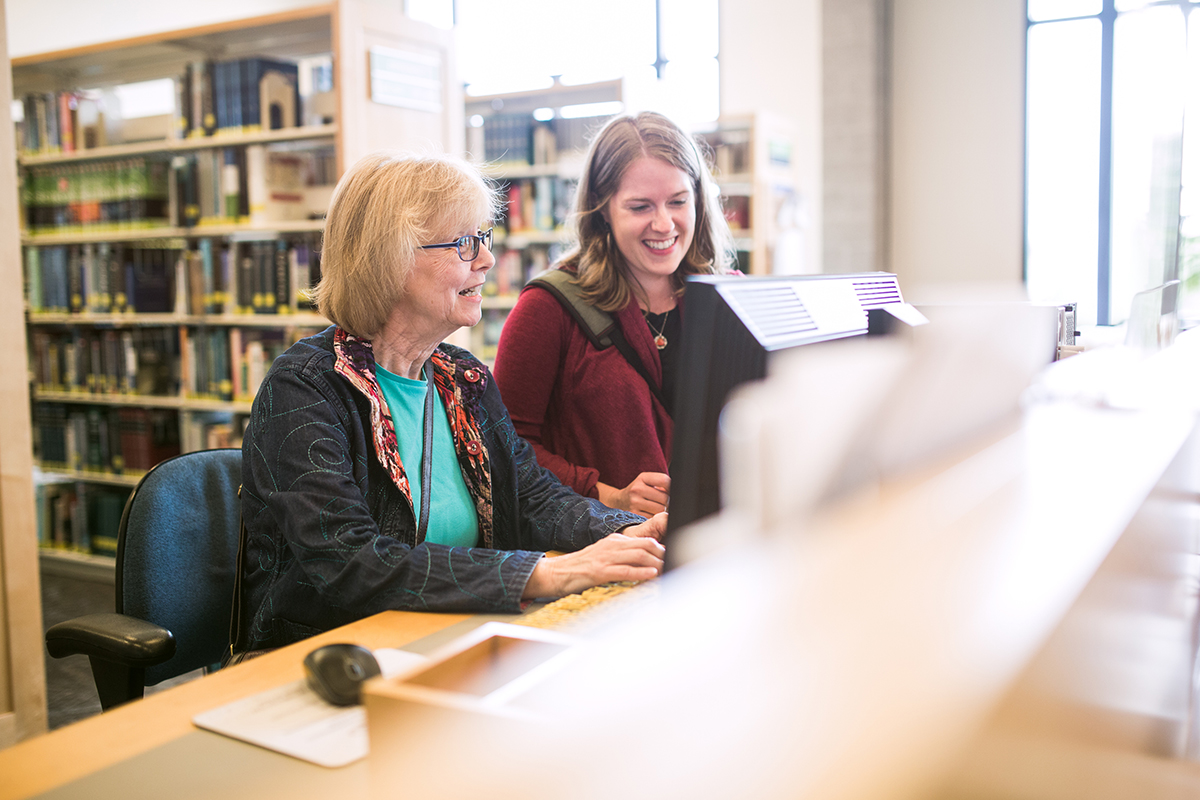 senior on the computer with a librarian