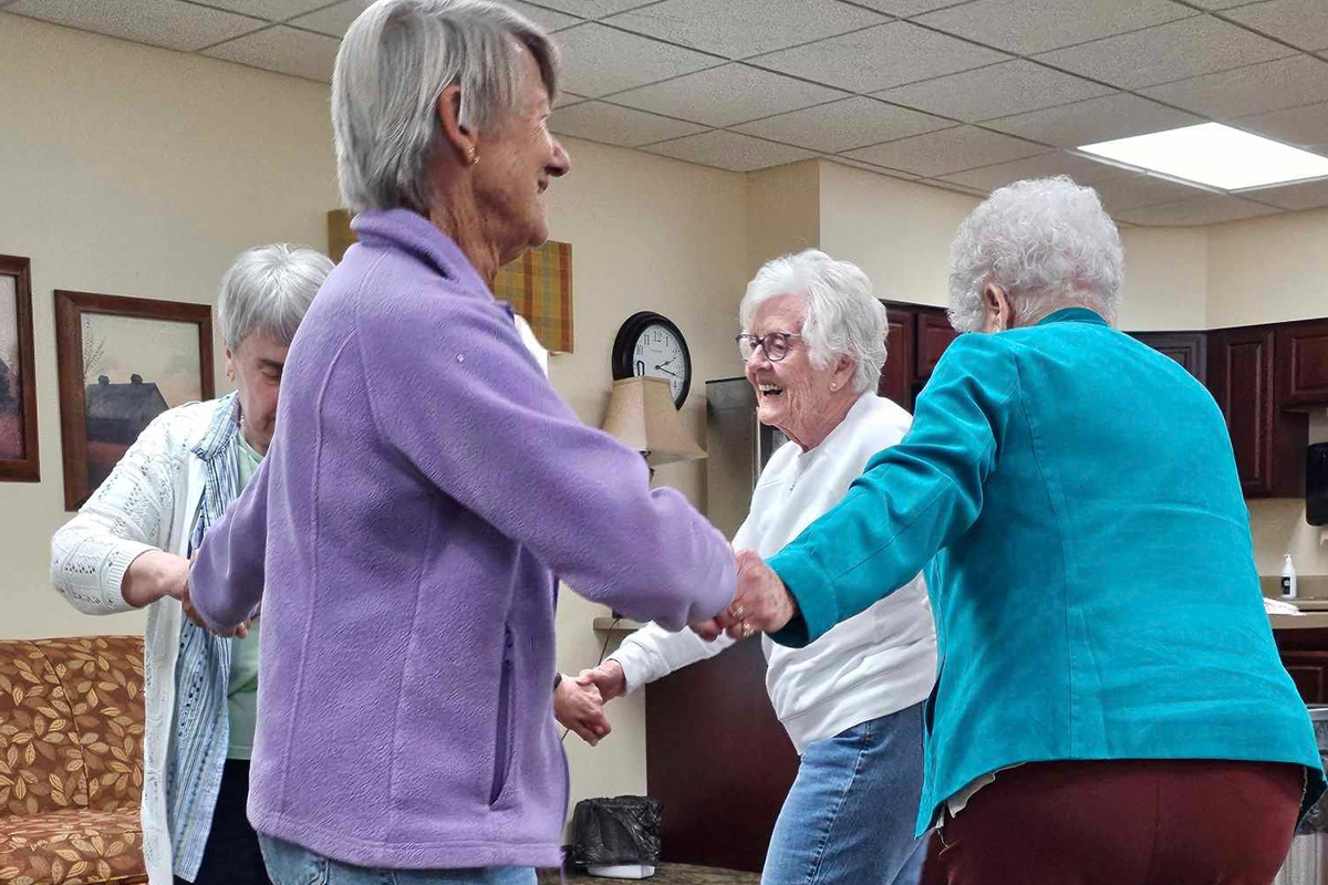 Four Oliver Woods residents dancing together.