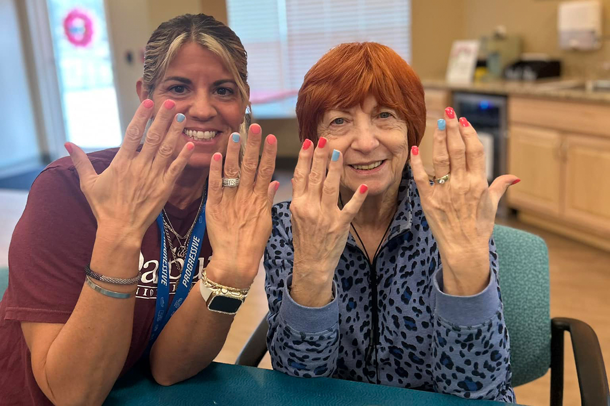 Danbury Brunswick resident and caregiver show the camera their manicures.