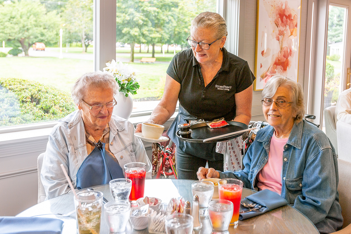 StoryPoint group residents receiving a meal in their shared dining room. 