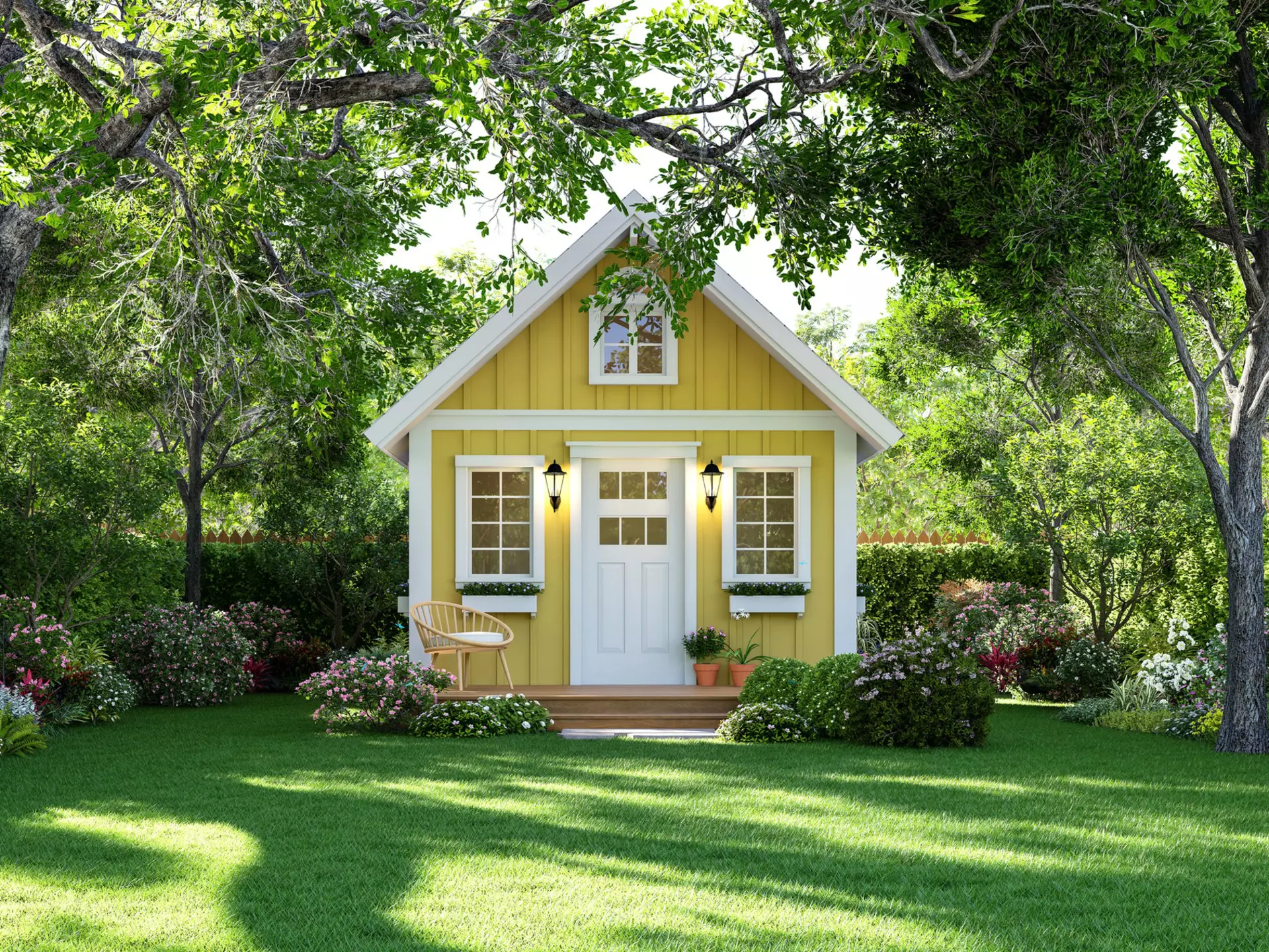 A yellow tiny home in a lush green yard.