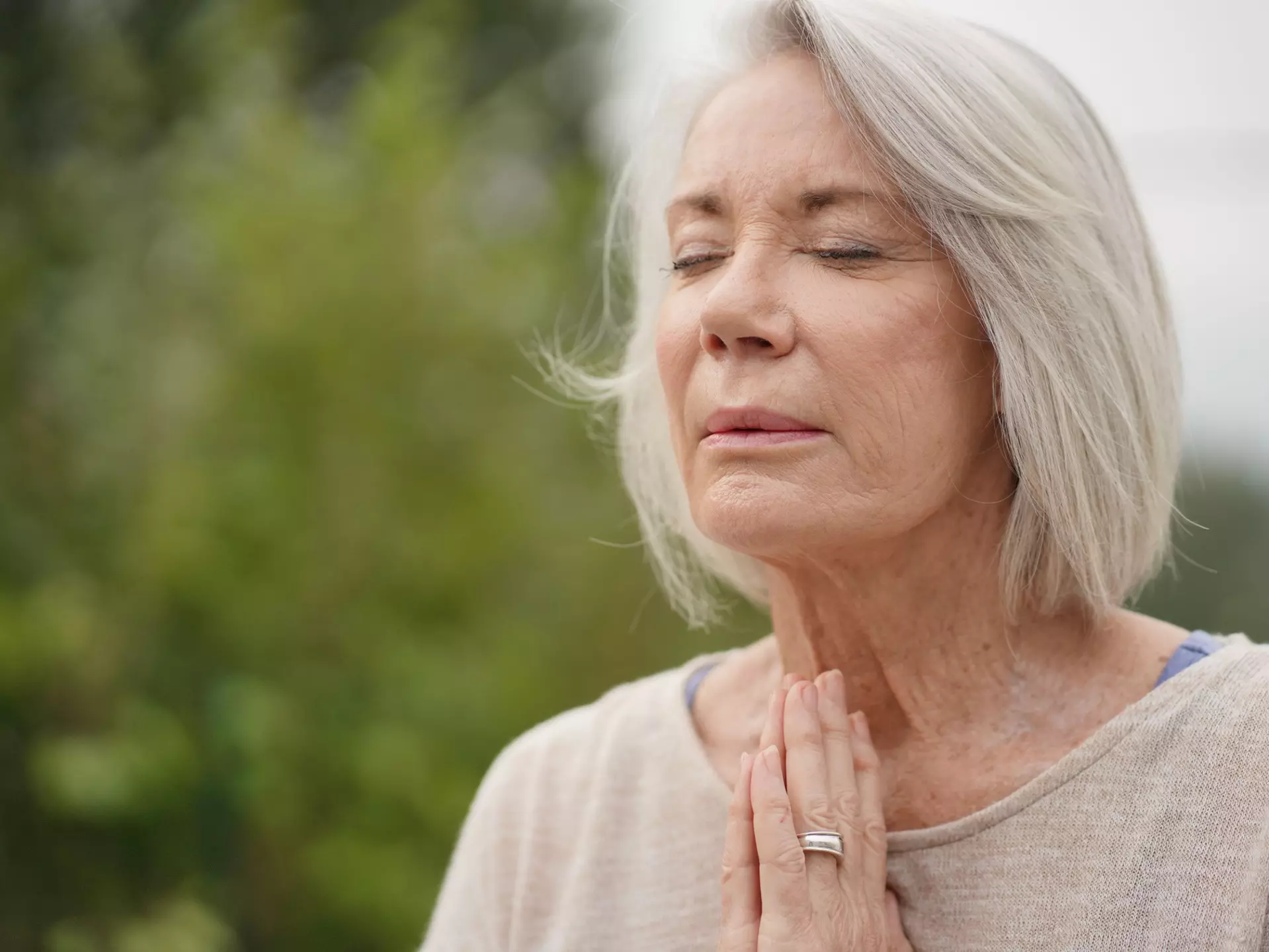 Senior woman with her eyes closed in a meditative position.