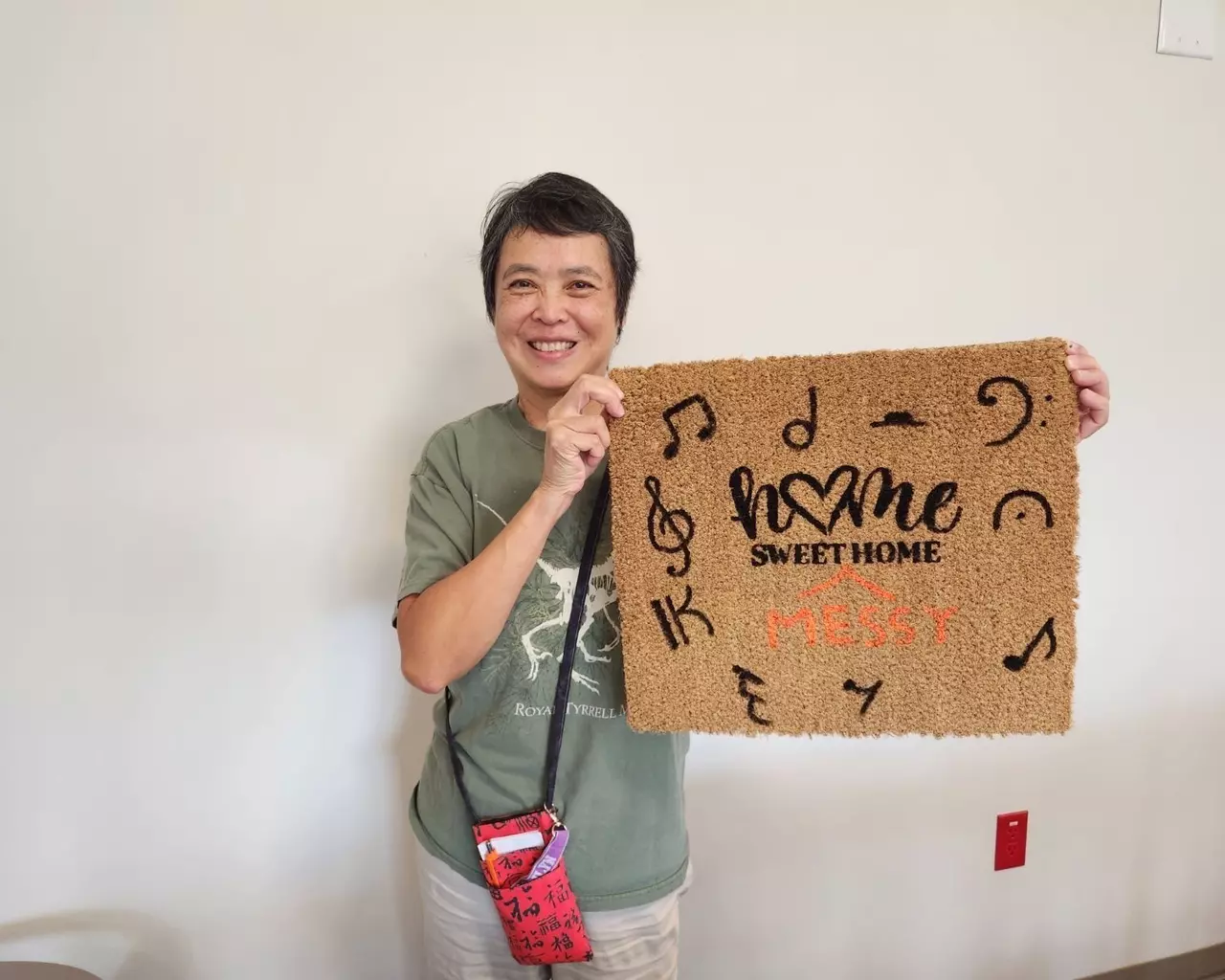 A StoryPoint group resident is showing off a welcome mat that they created.