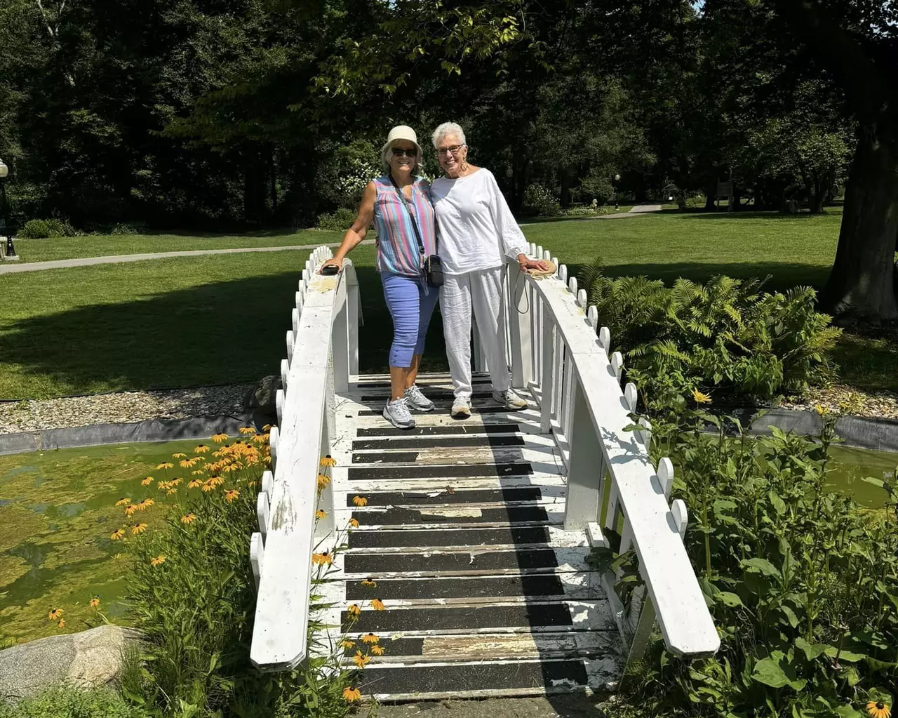 Two StoryPoint Residents are enjoying a garden walking path outside.